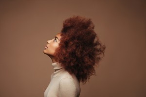 Photo of cheerful curly girl with positive emotions