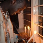 Yannick Tona lights a menorah. Photo by David Bruce.